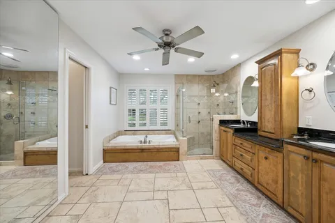a bathroom with a double vanity sink a mirror and a bathtub