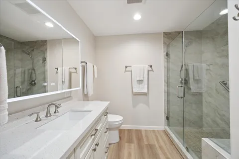 a bathroom with a sink a toilet and shower