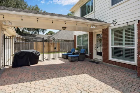 a view of a patio with table and chairs under an umbrella