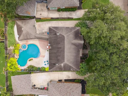 an aerial view of a house with a yard and a large tree