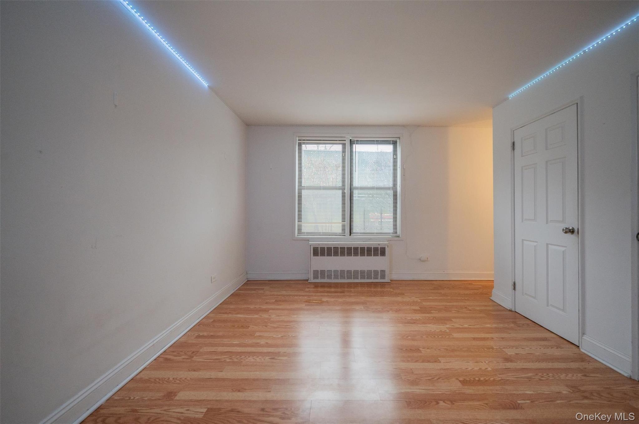 35-20 Leverich Street, Unit 209 Queens, NY 11372 - Photo 4 of 12 wooden floor in an empty room with a window