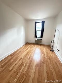 35-20 Leverich Street, Unit 209 Queens, NY 11372 - Photo 6 of 12 an empty room with wooden floor and windows