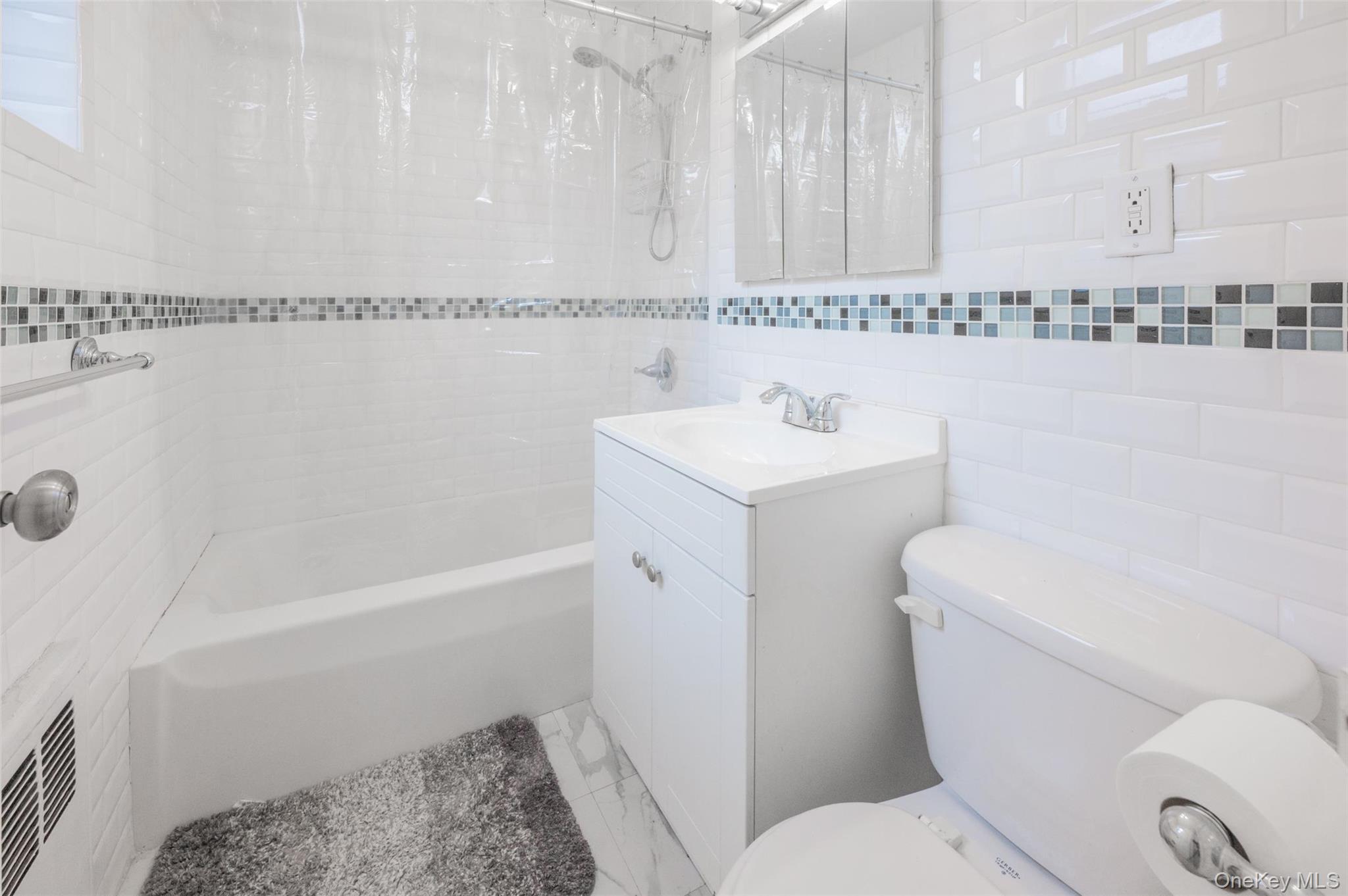 35-20 Leverich Street, Unit 209 Queens, NY 11372 - Photo 8 of 12 a bathroom with a sink a toilet and shower
