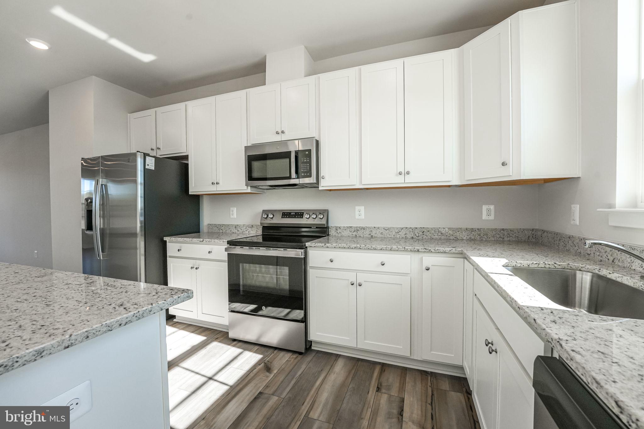 19122 Isabel Boulevard Appomattox, VA 24522 - Photo 14 of 35 a kitchen with granite countertop a sink stainless steel appliances and white cabinets
