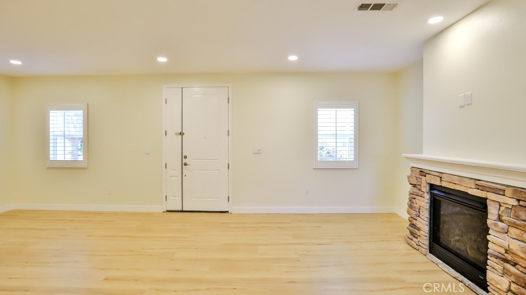 12388 Arrowhead Street Stanton, CA 90680 - Photo 11 of 69 a view of an empty room with wooden floor and a fireplace