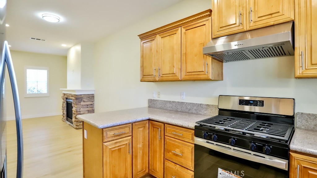 12388 Arrowhead Street Stanton, CA 90680 - Photo 16 of 69 a kitchen with stainless steel appliances granite countertop a stove and a refrigerator