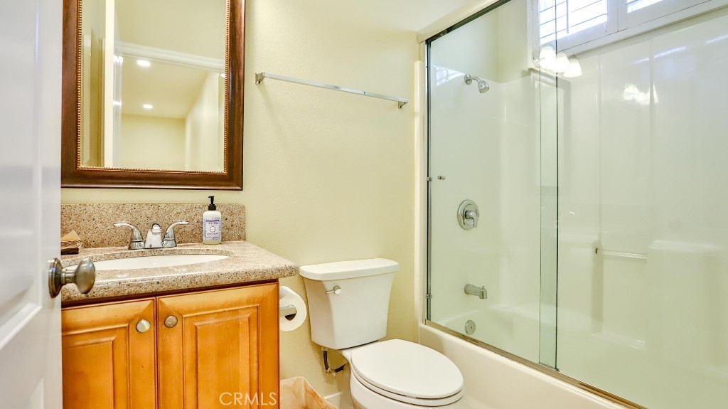 12388 Arrowhead Street Stanton, CA 90680 - Photo 25 of 69 a bathroom with a granite countertop sink toilet mirror and shower