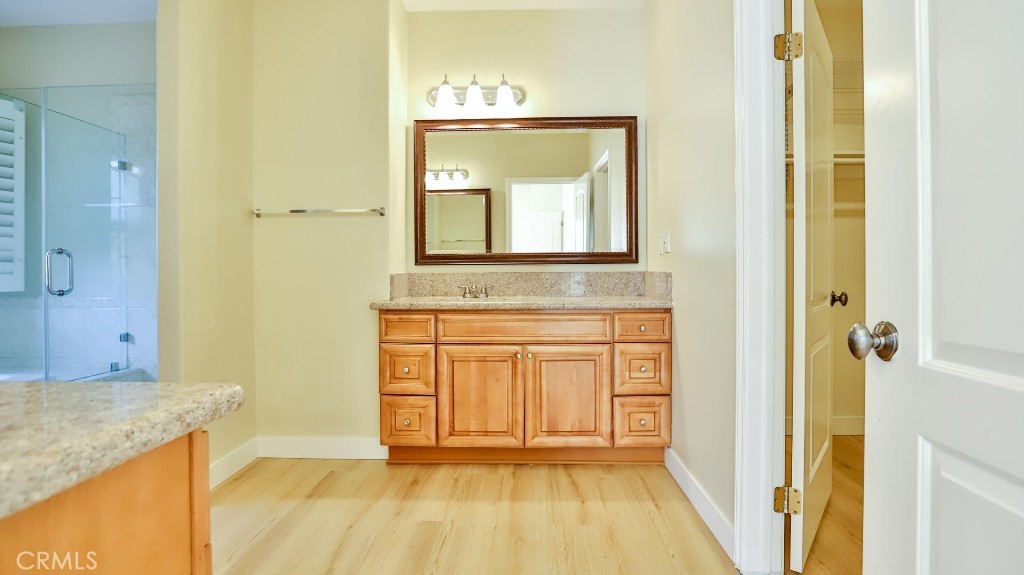 12388 Arrowhead Street Stanton, CA 90680 - Photo 38 of 69 a bathroom with a granite countertop sink a mirror and a bathtub