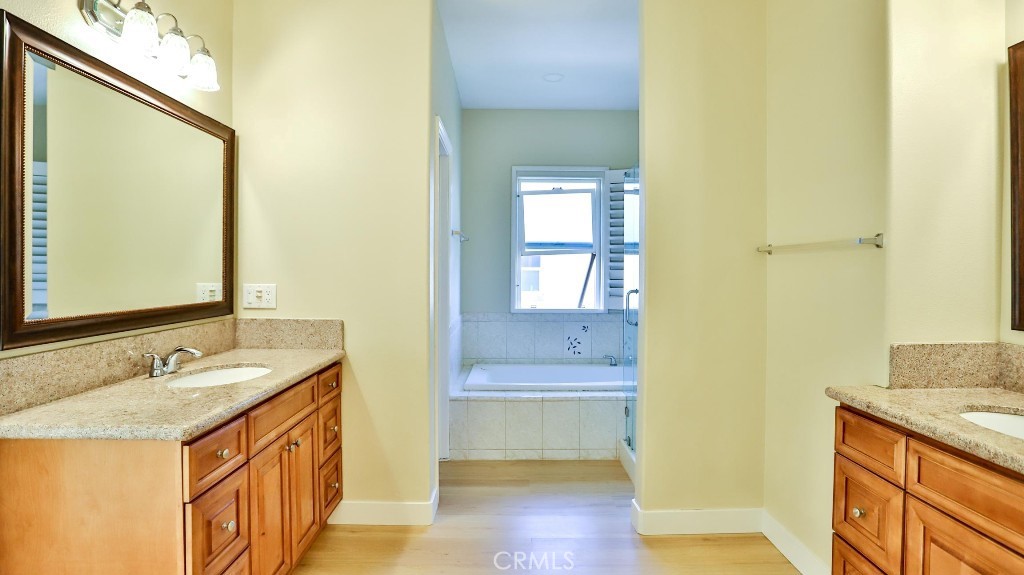 12388 Arrowhead Street Stanton, CA 90680 - Photo 40 of 69 a bathroom with a sink a mirror and a bathtub