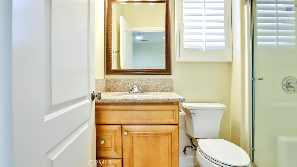 12388 Arrowhead Street Stanton, CA 90680 - Photo 49 of 69 a bathroom with a granite countertop toilet sink and mirror