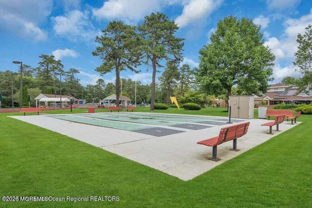 a group of people sitting under an umbrella in front of house