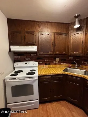 a kitchen with granite countertop a stove and a sink