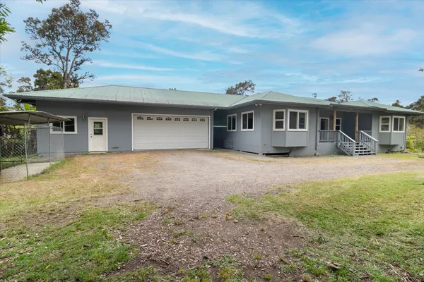 a front view of a house with a yard and potted plants