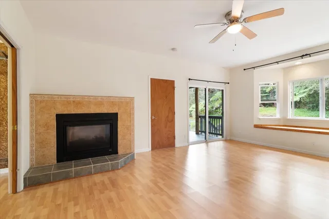 a view of an empty room with a fireplace and a window