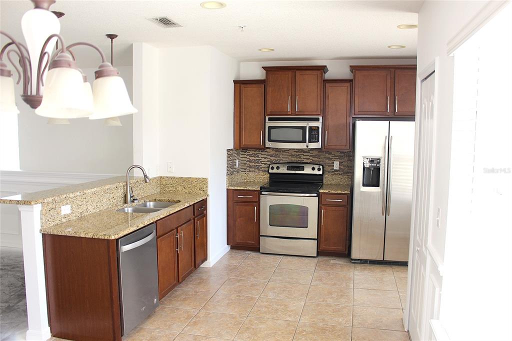 455 Old Farm Lane Winter Springs, FL 32708 - Photo 15 of 38 a kitchen with kitchen island granite countertop stainless steel appliances and cabinets
