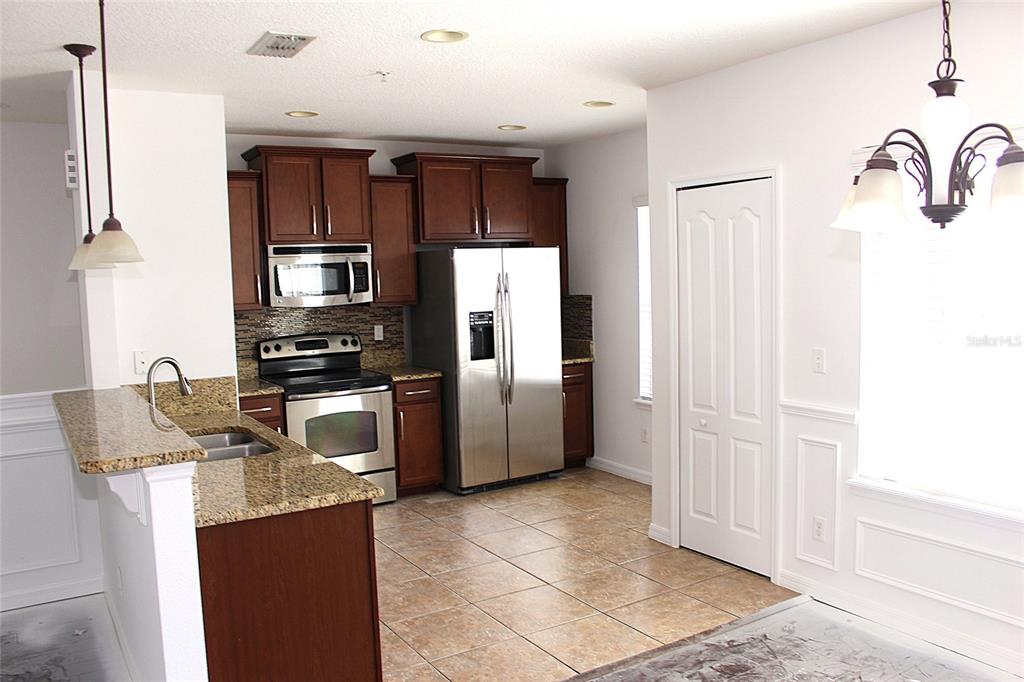 455 Old Farm Lane Winter Springs, FL 32708 - Photo 22 of 38 a kitchen with stainless steel appliances granite countertop a refrigerator and a stove top oven