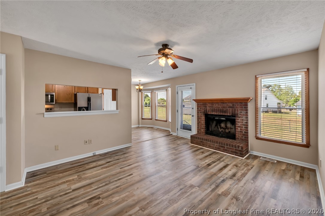 5262 Marvin Drive Spring Lake, NC 28390 - Photo 2 of 23 a view of a livingroom with a fireplace a ceiling fan and windows