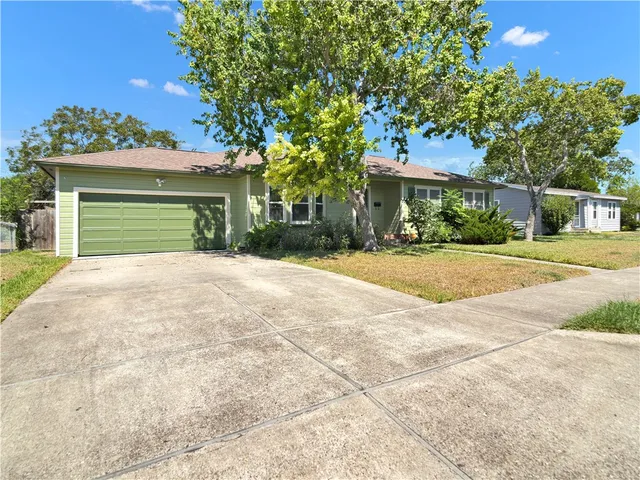 a view of a house with a yard and potted plants
