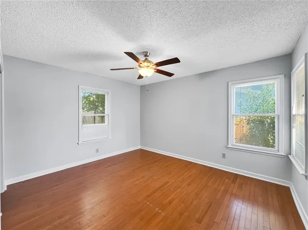 an empty room with a window and a ceiling fan