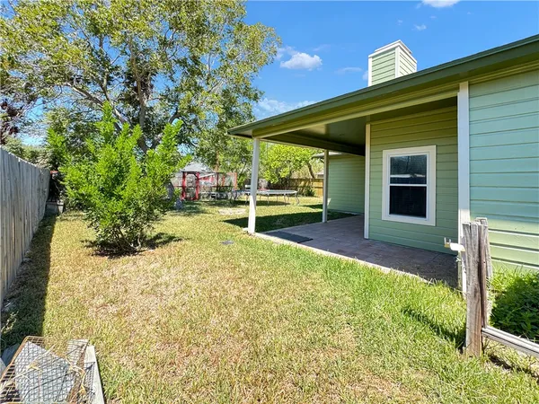 a view of a house with a yard and potted plants