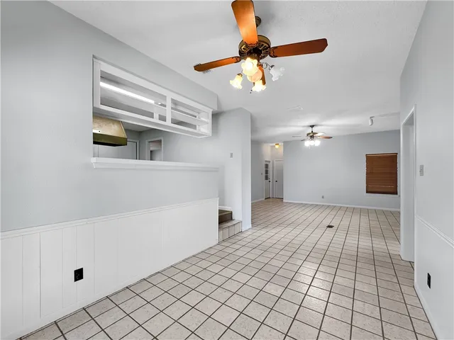 a view of a livingroom with a chandelier fan and wooden floor