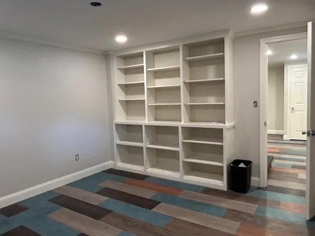 a room with wooden floor and windows
