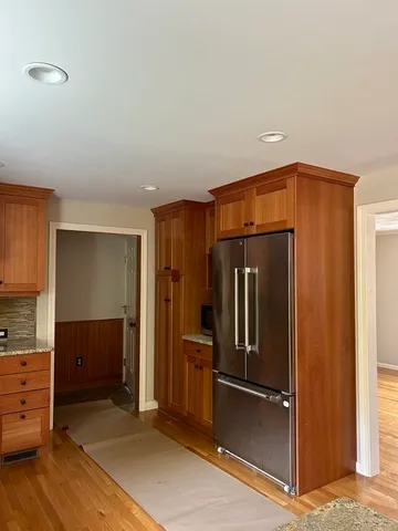 a view of kitchen with refrigerator and cabinets