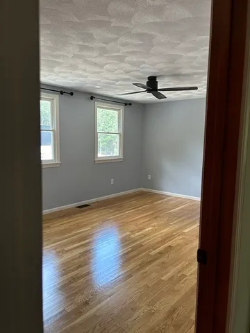 a view of a room with wooden floor and a window