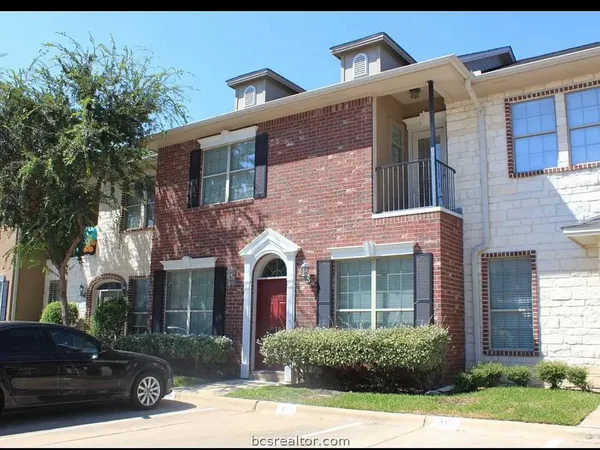a view of a brick house with a yard next to a yard