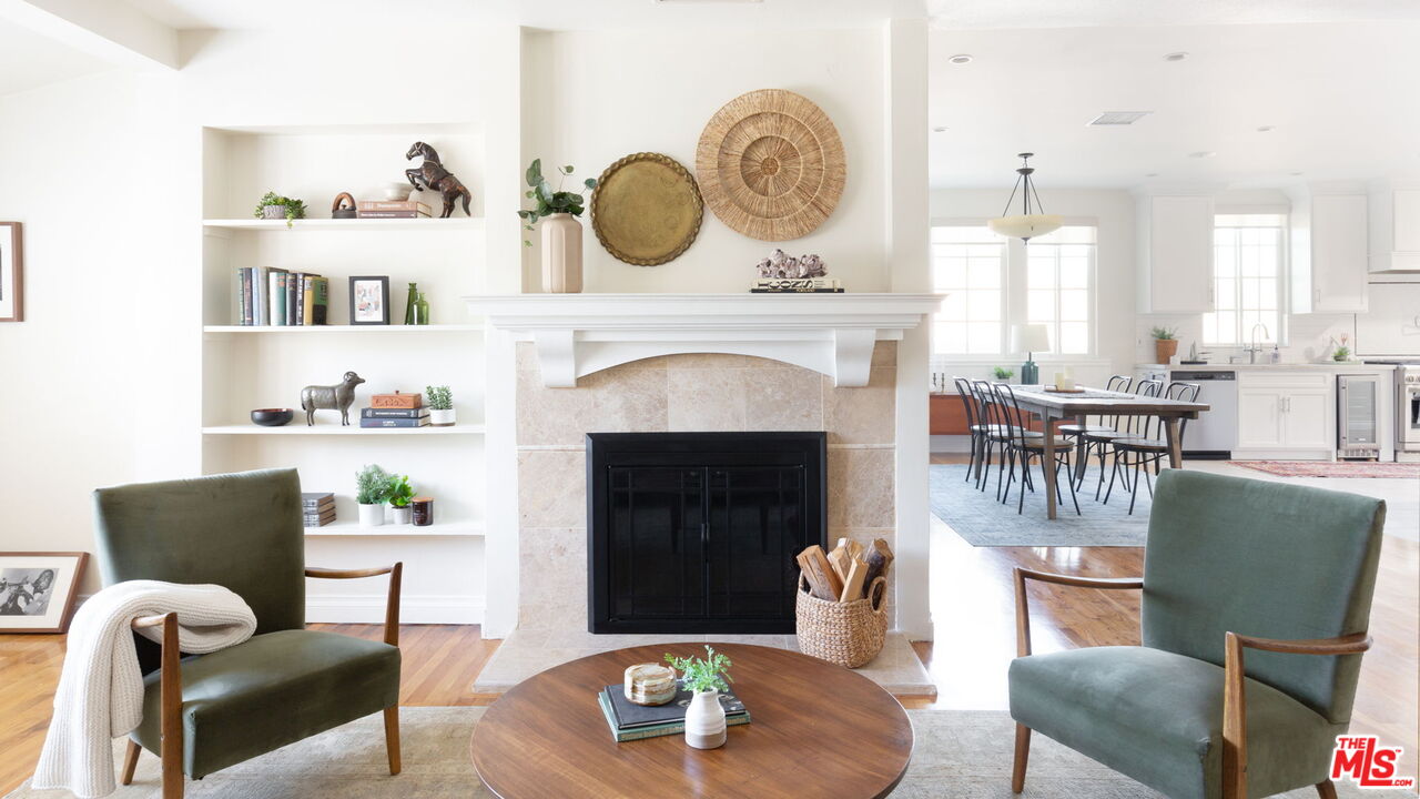 a living room with furniture a fireplace and kitchen view