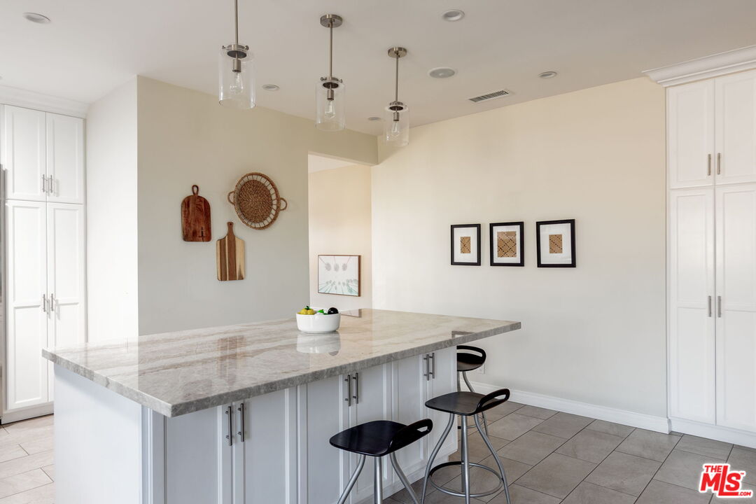 3810 Hauser Boulevard Los Angeles, CA 90008 - Photo 11 of 32 a kitchen with stainless steel appliances kitchen island a table and chairs in it