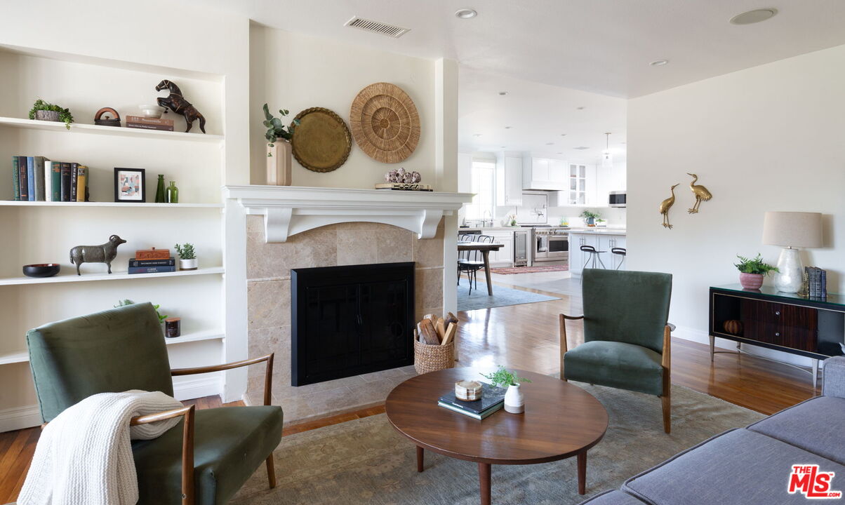 3810 Hauser Boulevard Los Angeles, CA 90008 - Photo 2 of 32 a living room with furniture a fireplace and kitchen view