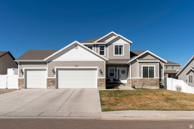 836 South 250 West Vernal, UT 84078 - Photo 54 of 56 Craftsman-style house with stone siding, an attached garage, driveway, and a gate