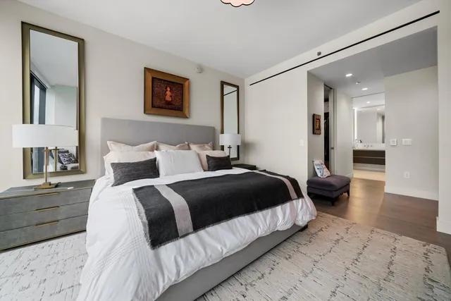 a bedroom with a large bed and a chandelier