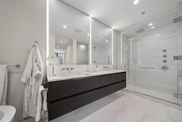 a bathroom with a double vanity sink mirror double and shower