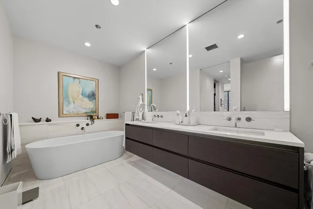 a bathroom with a large tub sink and mirror