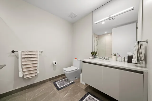 a bathroom with a toilet a sink and mirror