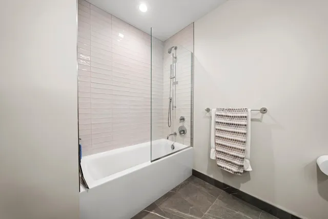 a bathroom with a bathtub a shower and a window