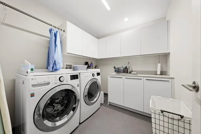 a utility room with sink dryer and washer