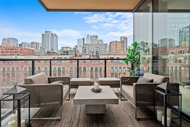 a view of a balcony with chairs and a potted plant
