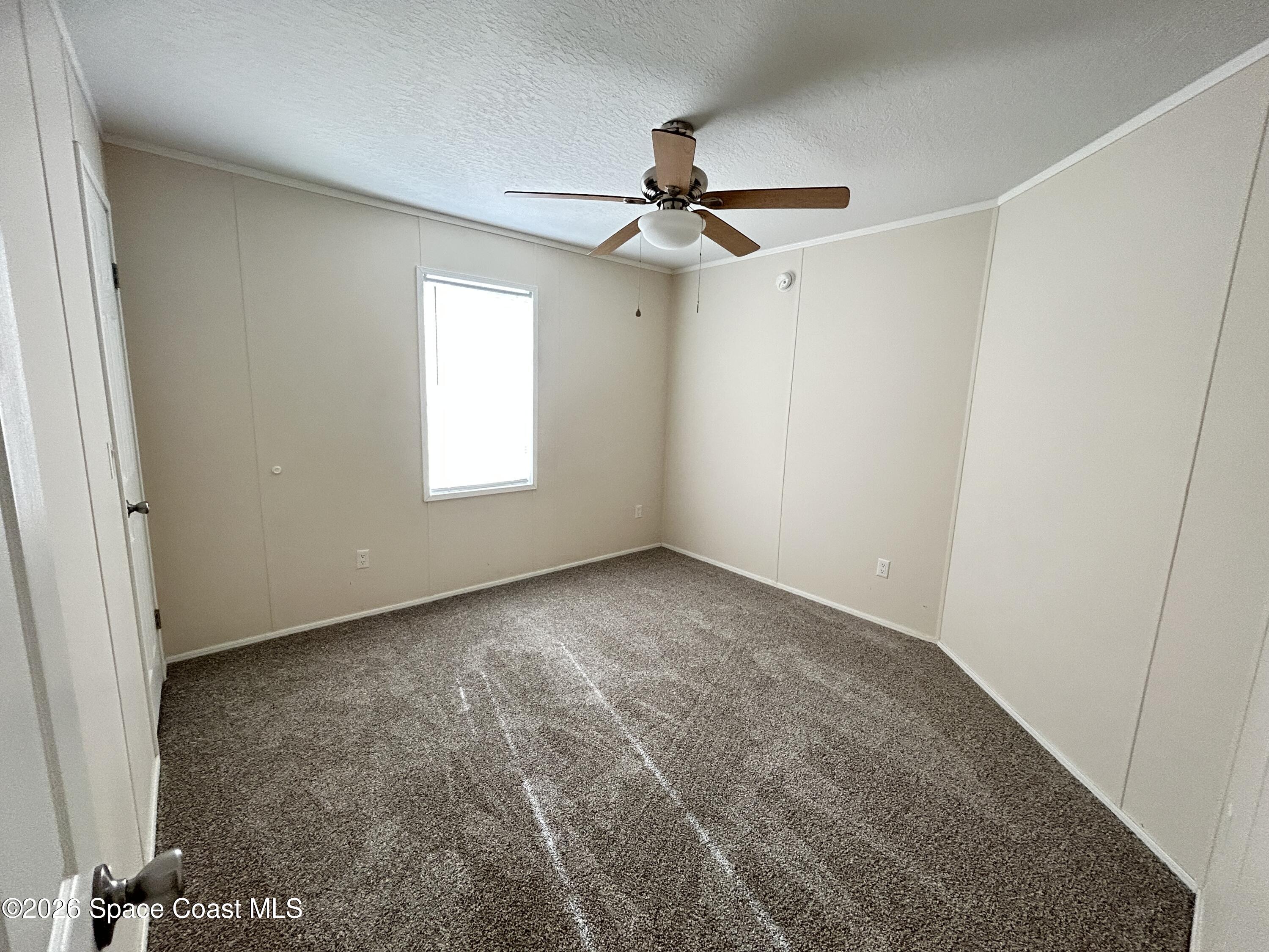 117 Lewis Street Edgewater, FL 32141 - Photo 17 of 26 an empty room with windows and fan