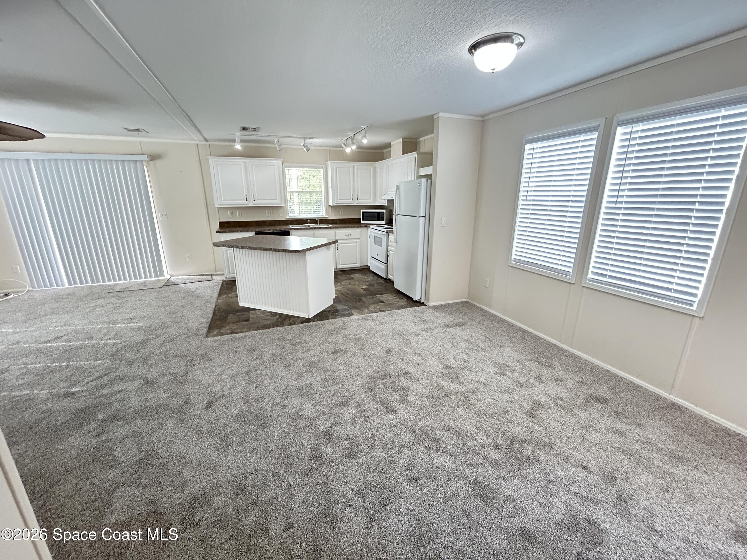 117 Lewis Street Edgewater, FL 32141 - Photo 7 of 26 a view of kitchen and empty room with wooden floor