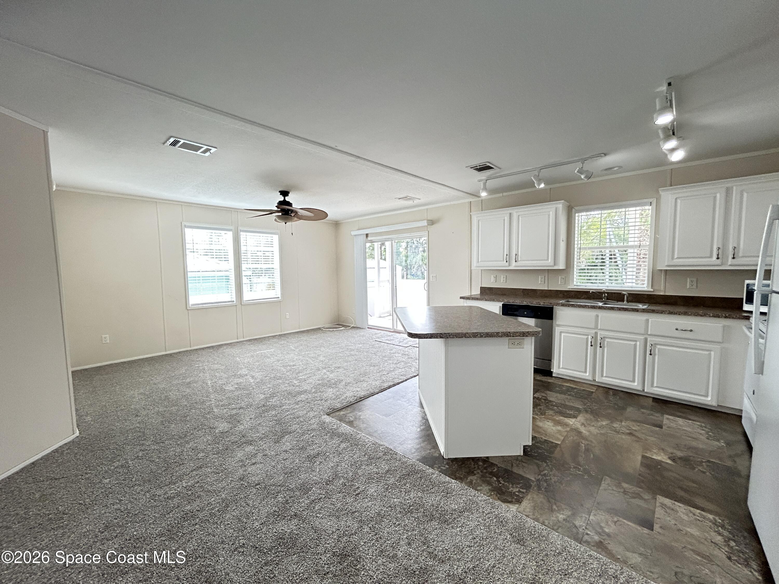 117 Lewis Street Edgewater, FL 32141 - Photo 8 of 26 a kitchen with a refrigerator a sink and cabinets