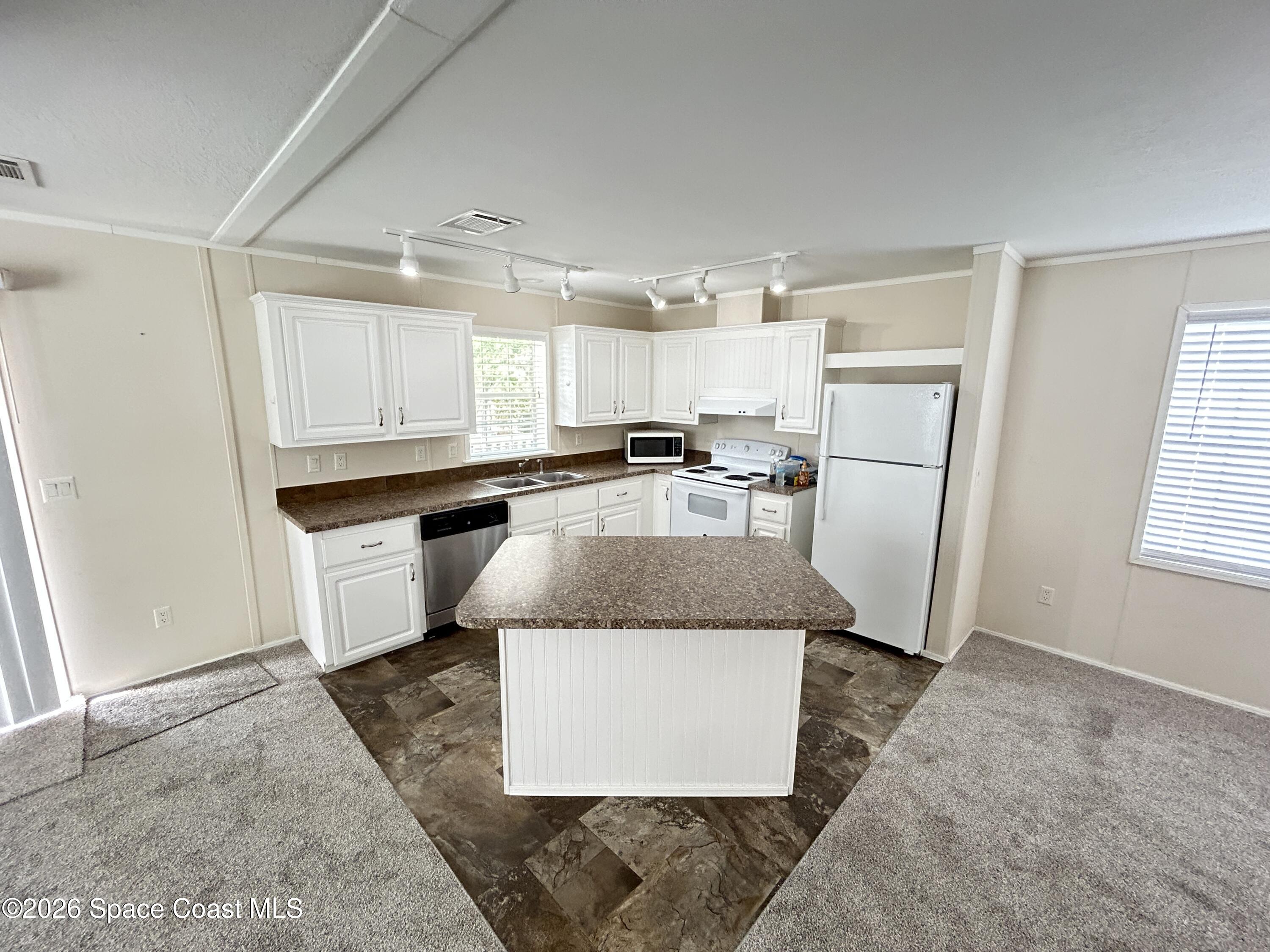 117 Lewis Street Edgewater, FL 32141 - Photo 9 of 26 a kitchen with stainless steel appliances granite countertop a sink stove and refrigerator