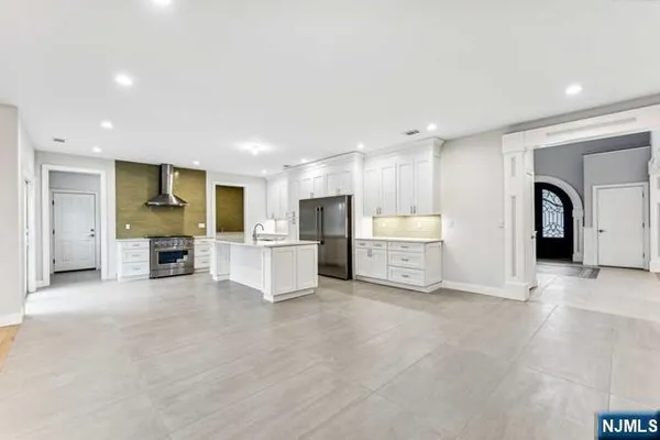 a view of an empty room with wooden floor and closet