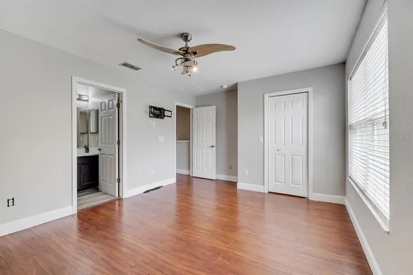 a view of a livingroom with wooden floor and a ceiling fan
