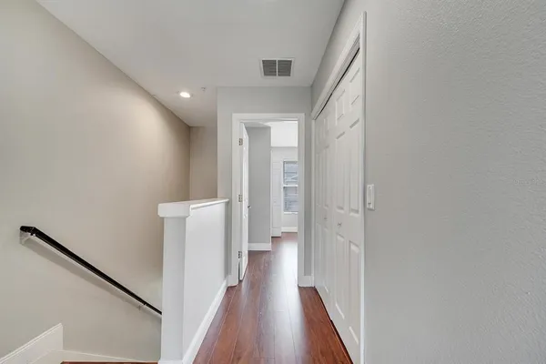 a view of a hallway with wooden floor and staircase