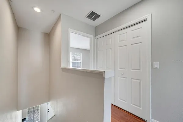 a view of an empty room with windows and closet