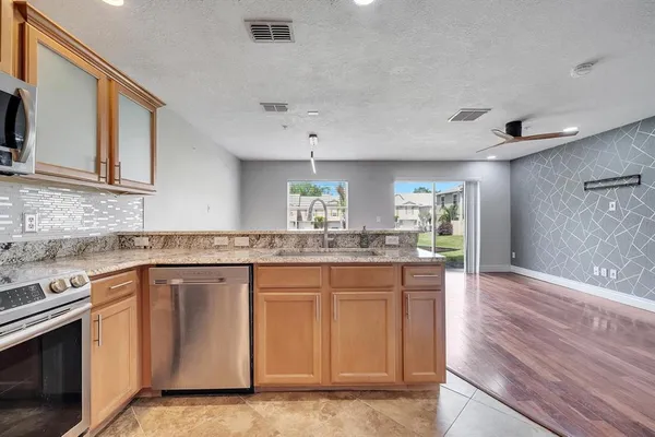 a kitchen with granite countertop a sink and cabinets