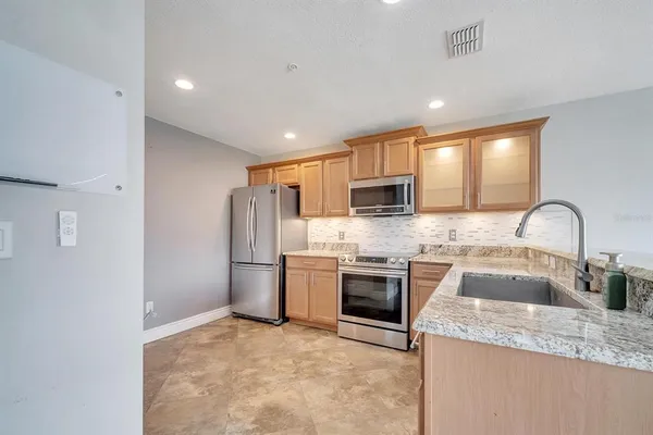 a kitchen with stainless steel appliances granite countertop a sink stove oven and refrigerator